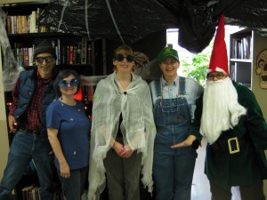 Four University of Illinois Press employees, and some really scary guy, at the Press Halloween party.