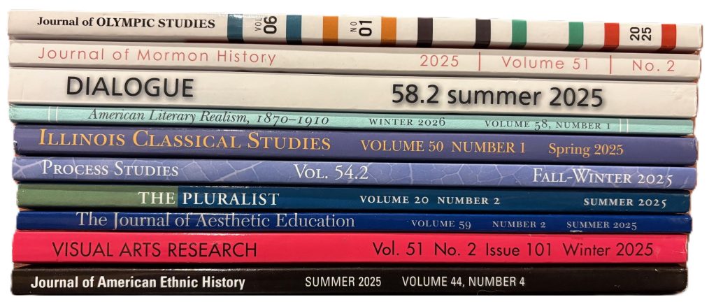 Stack of journal issues top to bottom: Journal of Olympic Studies Vol., No. 1, 2025, white spine; Journal of Momon History Vol. 51, No. 2, 2025, white spine; Dialogue: A Journal of Mormon Thought Vol. 58, No. 2, Summer 2025, white spine; American Literary Realism, 1870-1910, Vol. 58, No. 1, Winter 2026, teal spine; Illinois Classical Studies Vol. 50, No. 1, Spring 2025, blue spine; Process Studies Vol. 54, No. 2, Fall-Winter 2025, blue spine; The Pluralist Vol. 20, No. 2, Summer 2025, blue and green spine; The Journal of Aesthetic Education Vol. 59, No. 2, Summer 2025, blue spine; Visual Arts Research Vol. 51, No. 2, Issue 101, Winter 2025, pink spine; Journal of American Ethnic History Vol. 44, No. 4, Summer 2025, black spine.