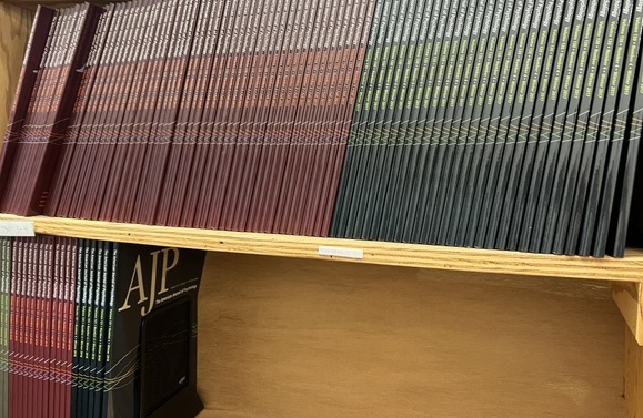 Picture of a shelf full of issues of American Journal of Psychology, some with red spines and some a dark navy/gray.