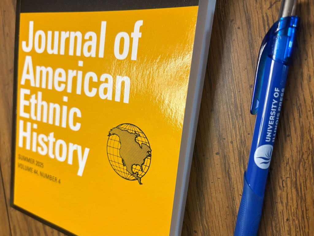 A Journal of American Ethnic History issue on a table next to a University of Illinois Press branded pen.