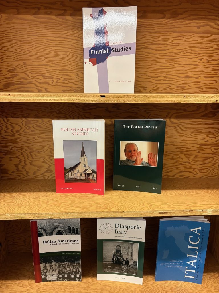 Journals arranged in a pyramid shape on three shelves. Shelf 1: Journal of Finnish Studies. Shelf 2: Polish American Studies and The Polish Review. Shelf 3: Italian Americana, Diasporic Italy, and Italica.
